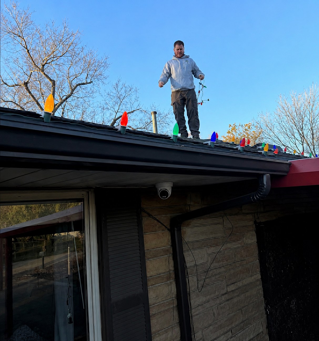 Christmas light installer working on a roofline